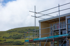 Corner of a house under construction with hills in the background